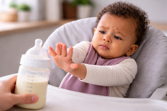 Baby rejecting bottle of milk