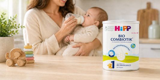 Mother feeding baby a bottle of HiPP organic formula