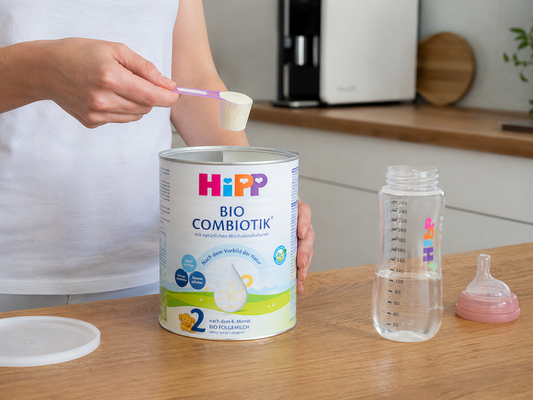 Woman scooping formula from HiPP can