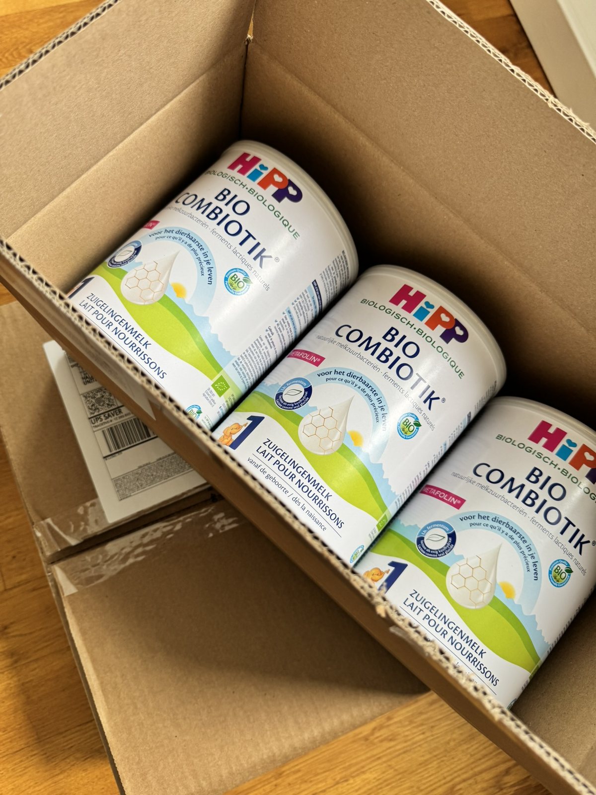 Three formula cans packed in a shipping box